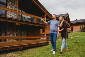 a man and a woman walking in front of a building at Chalets Jasná Collection - Apartments in Belá