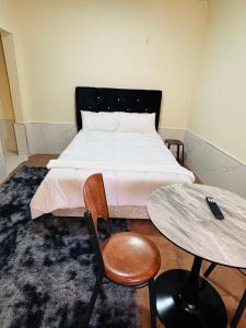 a bedroom with a bed and a table and chairs at ELISAM Cabin 2 in Kitwe +4 photos