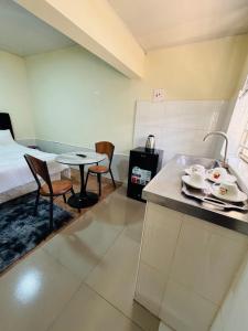 a room with a kitchen and a bed and a table at ELISAM Cabin 2 in Kitwe