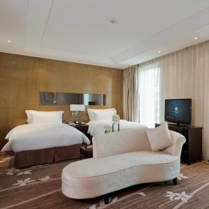a hotel room with two beds and a couch at The Jade Boutique Hotel in Wuhan