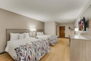 a hotel room with two beds and a flat screen tv at Red Roof Inn & Suites Newport - Middletown, RI in Middletown +43 photos