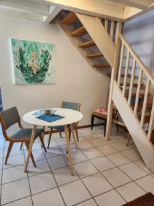 a dining room with a table and chairs and stairs at L'Escapade de Zillis in Zillisheim