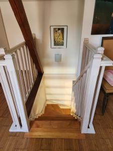 a staircase with white railings and wood floors at L'Escapade de Zillis in Zillisheim