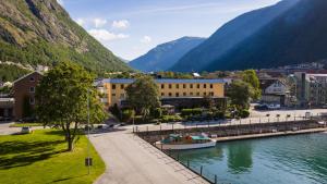 a town next to a river with mountains at Klingenberg Hotel - Årdal in Årdalstangen