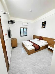 a bedroom with a bed and a television in it at Minh Anh Hotel Nghệ An in Vinh