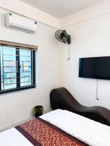a bedroom with a bed with a fan and a window at Minh Anh Hotel Nghệ An in Vinh