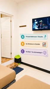 Ein Zimmer mit einem Schild und einem Fernseher an der Wand. in der Unterkunft Moshi Moshi in Probolinggo