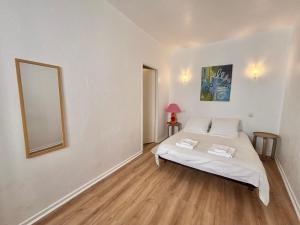 a bedroom with a bed and a mirror on the wall at Charmant Duplex climatisé, Centre de Cahors in Cahors