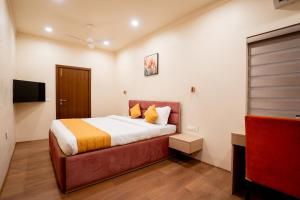 a bedroom with a bed and a flat screen tv at Fit Haus - A Boutique Hotel in Kolkata