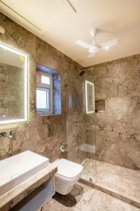 a bathroom with a sink and a toilet and a shower at Fit Haus - A Boutique Hotel in Kolkata