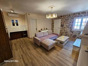 a living room with a couch and a stone wall at PELION HORIZON houses in Agios Ioannis Pelio
