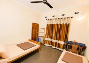 a living room with a bed and a ceiling fan at Yarl Retreat - Jaffna Town - Non-AC in Jaffna