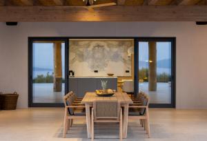 a dining room with a wooden table and chairs at Villa Kairos in Foiníki
