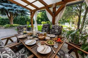 a wooden table with plates of food on it at Apartman Karlina 100 m2 Terrace Garden in Šahy