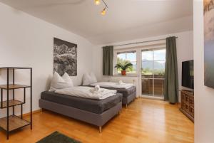 a bedroom with two beds and a television at Bergvilla-Ramsau in Ramsau am Dachstein