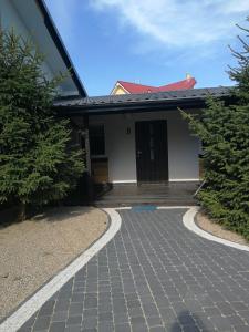 a house with a brick walkway in front of it at Domki Pod Szyszką 500m od morza in Rowy +47 photos