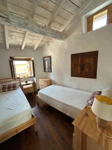 a bedroom with two twin beds and a window at Cal Toni de Vilallobent in Vilallovent
