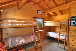 a bedroom with two bunk beds in a log cabin at Charming Chalet w/ Mountain & Slope Views, Jacuzzi in Vars +39 photos