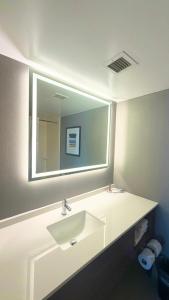 a bathroom with a white sink and a mirror at Charlotte Suites by IHG in Charlotte