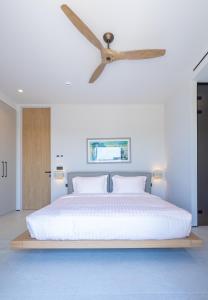 a bedroom with a large bed with a ceiling fan at Villa Kairos in Foiníki +53 photos