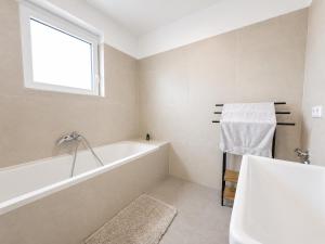 a white bathroom with a tub and a window at TO-HAD, Modern Apartments next to U-bahn with free Wifi in Vienna +42 photos