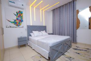 a bedroom with a large bed and a painting on the wall at 3 bedrooms Entebbe Lake-House with Pool,Private Beach, Kids Park and AC in Kagolomolo +60 photos