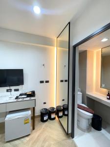a bathroom with a toilet and a sink and a mirror at RESET at DMK Hotel in Don Muang Airport