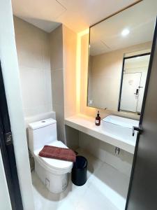 a bathroom with a toilet and a mirror at RESET at DMK Hotel in Don Muang Airport