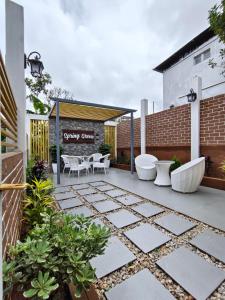 a patio with white furniture and a building at Spring Grove B&B in Jowai
