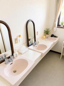 a bathroom with three sinks and two mirrors at Heart Warmer in Myoko +10 photos