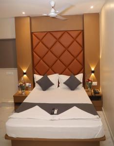 ein Schlafzimmer mit einem großen Bett mit braunem Kopfteil in der Unterkunft Hotel Pramila in Mumbai