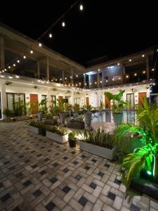 a building with a courtyard with potted plants and lights at Lumora Fresh Wave Arugambay in Arugam Bay