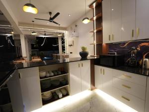 a kitchen with white cabinets and black counter tops at Lumora Fresh Wave Arugambay in Arugam Bay