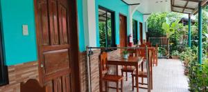 a porch with a table and chairs and a door at Rabang Inn in San Vicente