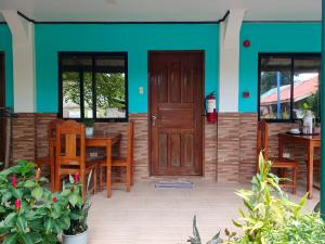 a patio with a wooden door and tables and chairs at Rabang Inn in San Vicente