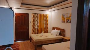 a small room with a bed and a table at Rabang Inn in San Vicente