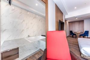 a hotel room with a red chair and a bed at Dyne Oceano Hotel in Jeju +176 photos