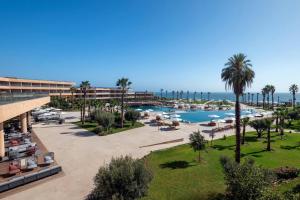 an aerial view of a resort with a pool and the ocean at Taghazout Bay Marriott Resort in Taghazout