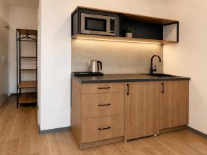 a kitchen with a sink and a microwave at Blue Stay Bremen in Bremen