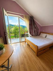 a bedroom with a bed and a large window at cottage in tsemi (Borjomi) in Borjomi