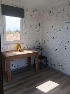 a room with a wooden table and a window at ИНХаус Долинка in Cholpon-Ata