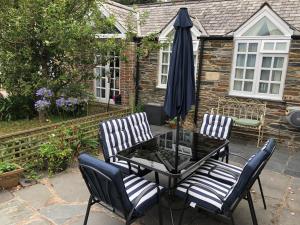 a patio with a table and chairs and an umbrella at The Nook in Padstow