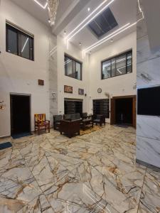 a large room with a stone floor and ceilings with windows at Vrindavan Villa Homestay in Cherambane