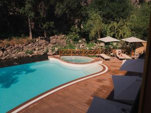 a swimming pool in a yard with chairs and umbrellas at Red Bridge Yerevan in Yerevan