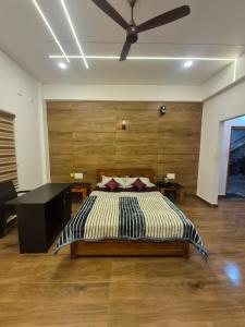 a bedroom with a bed and a ceiling fan at Vrindavan Villa Homestay in Cherambane
