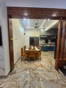 a dining room with a table and chairs in a kitchen at Vrindavan Villa Homestay in Cherambane