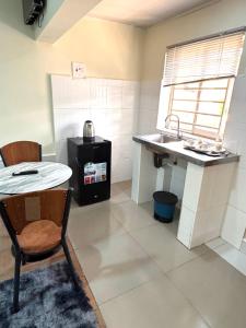 a small kitchen with a table and a sink at ELISAM Cabin 2 in Kitwe