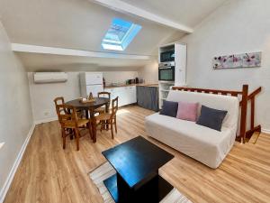 a living room with a couch and a table at Charmant Duplex climatisé, Centre de Cahors in Cahors