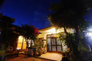 a house with trees and plants in front of it at 民宿池田屋 in Taketomi