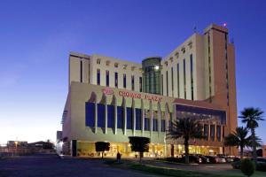 a large building with a colgate pharmacy sign on it at Crowne Plaza Torreon by IHG in Torreón